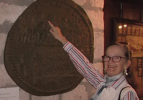 Annie Peysson, guide franco-allemande, devant le médaillon de plomb de Lyon